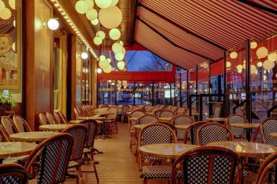 Un liquide enflammé est versé d'une petite carafe dans un verre rempli de glaçons sur une table.