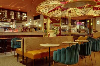 Un liquide enflammé est versé d'une petite carafe dans un verre rempli de glaçons sur une table.