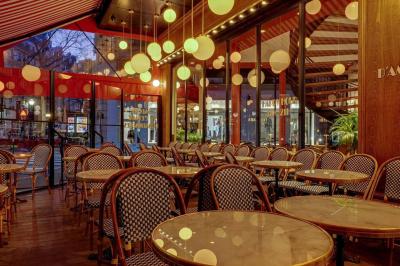 Un liquide enflammé est versé d'une petite carafe dans un verre rempli de glaçons sur une table.