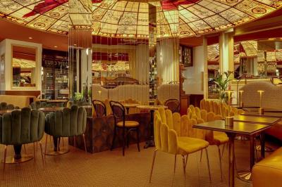 Un liquide enflammé est versé d'une petite carafe dans un verre rempli de glaçons sur une table.