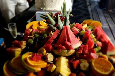 Huîtres gratinées garnies de fromage et épices, présentées sur un plateau en bois, avec légumes en arrière-plan.