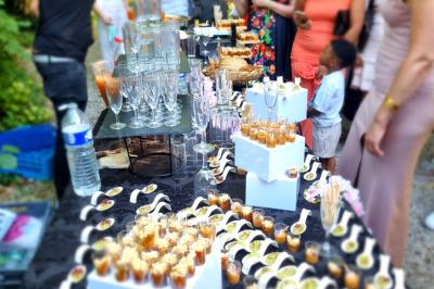 Huîtres gratinées garnies de fromage et épices, présentées sur un plateau en bois, avec légumes en arrière-plan.