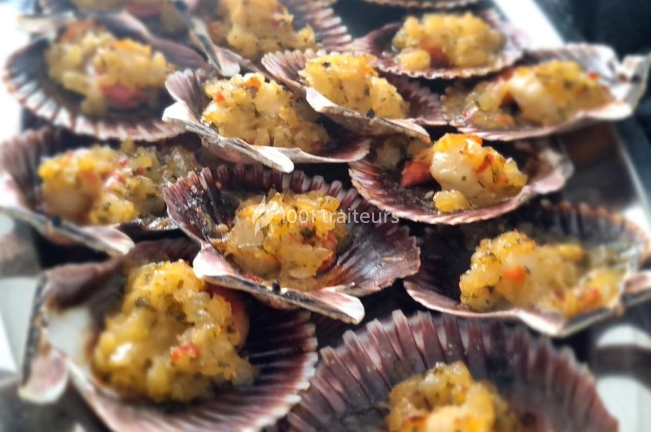 Coquilles Saint-Jacques garnies de farce dorée aux herbes et épices, présentées sur un plateau.