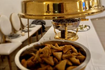 Huîtres gratinées garnies de fromage et épices, présentées sur un plateau en bois, avec légumes en arrière-plan.