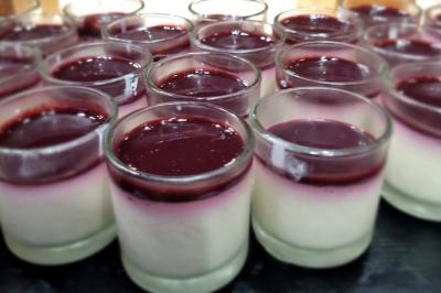 Huîtres gratinées garnies de fromage et épices, présentées sur un plateau en bois, avec légumes en arrière-plan.