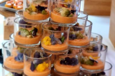 Huîtres gratinées garnies de fromage et épices, présentées sur un plateau en bois, avec légumes en arrière-plan.