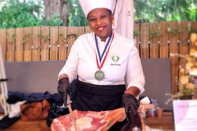 Huîtres gratinées garnies de fromage et épices, présentées sur un plateau en bois, avec légumes en arrière-plan.