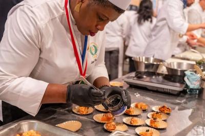 Huîtres gratinées garnies de fromage et épices, présentées sur un plateau en bois, avec légumes en arrière-plan.