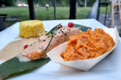 Huîtres gratinées garnies de fromage et épices, présentées sur un plateau en bois, avec légumes en arrière-plan.