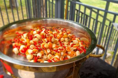 Huîtres gratinées garnies de fromage et épices, présentées sur un plateau en bois, avec légumes en arrière-plan.
