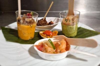 Huîtres gratinées garnies de fromage et épices, présentées sur un plateau en bois, avec légumes en arrière-plan.