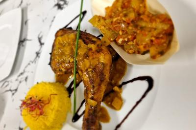 Huîtres gratinées garnies de fromage et épices, présentées sur un plateau en bois, avec légumes en arrière-plan.