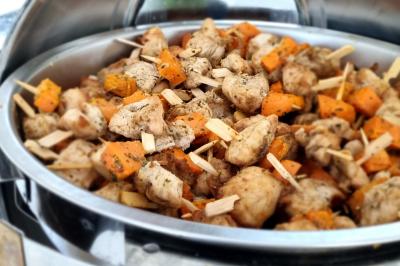 Huîtres gratinées garnies de fromage et épices, présentées sur un plateau en bois, avec légumes en arrière-plan.