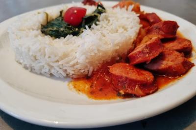 Huîtres gratinées garnies de fromage et épices, présentées sur un plateau en bois, avec légumes en arrière-plan.