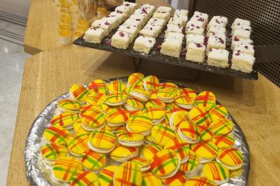 Huîtres gratinées garnies de fromage et épices, présentées sur un plateau en bois, avec légumes en arrière-plan.