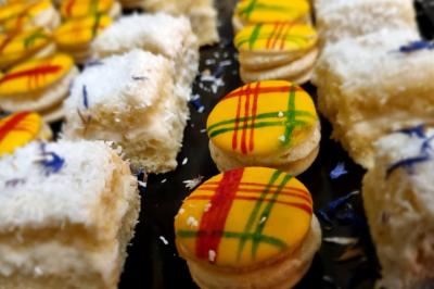 Huîtres gratinées garnies de fromage et épices, présentées sur un plateau en bois, avec légumes en arrière-plan.