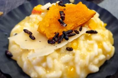 Huîtres gratinées garnies de fromage et épices, présentées sur un plateau en bois, avec légumes en arrière-plan.