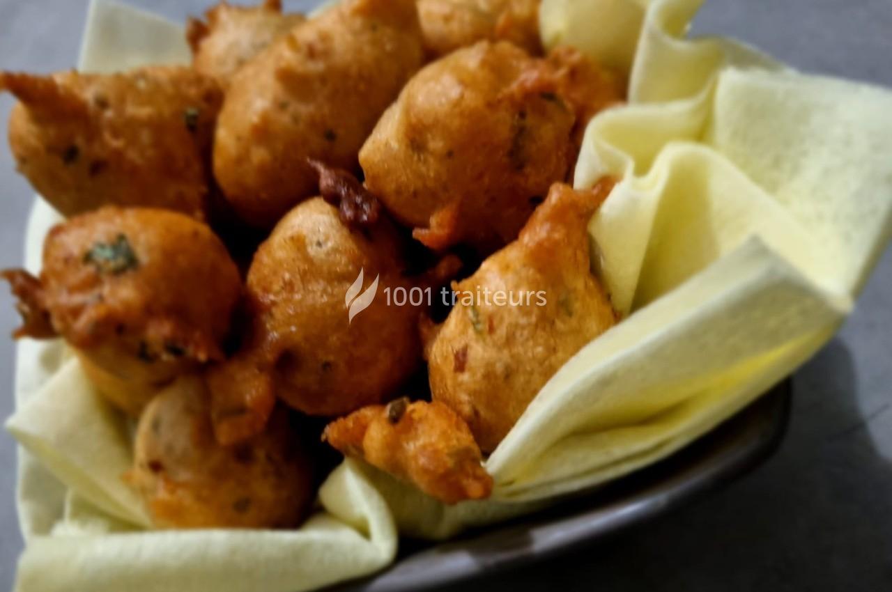 Beignets dorés et croustillants disposés dans un bol garni de serviettes en tissu clair.