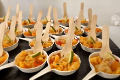 Huîtres gratinées garnies de fromage et épices, présentées sur un plateau en bois, avec légumes en arrière-plan.