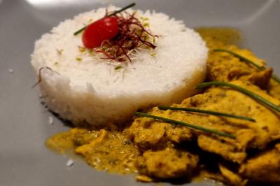 Huîtres gratinées garnies de fromage et épices, présentées sur un plateau en bois, avec légumes en arrière-plan.