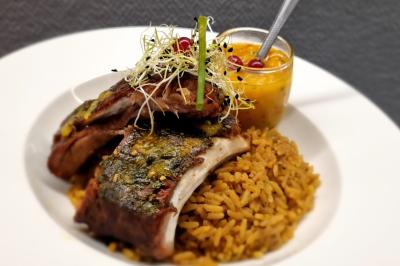 Huîtres gratinées garnies de fromage et épices, présentées sur un plateau en bois, avec légumes en arrière-plan.