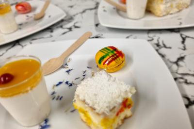 Huîtres gratinées garnies de fromage et épices, présentées sur un plateau en bois, avec légumes en arrière-plan.