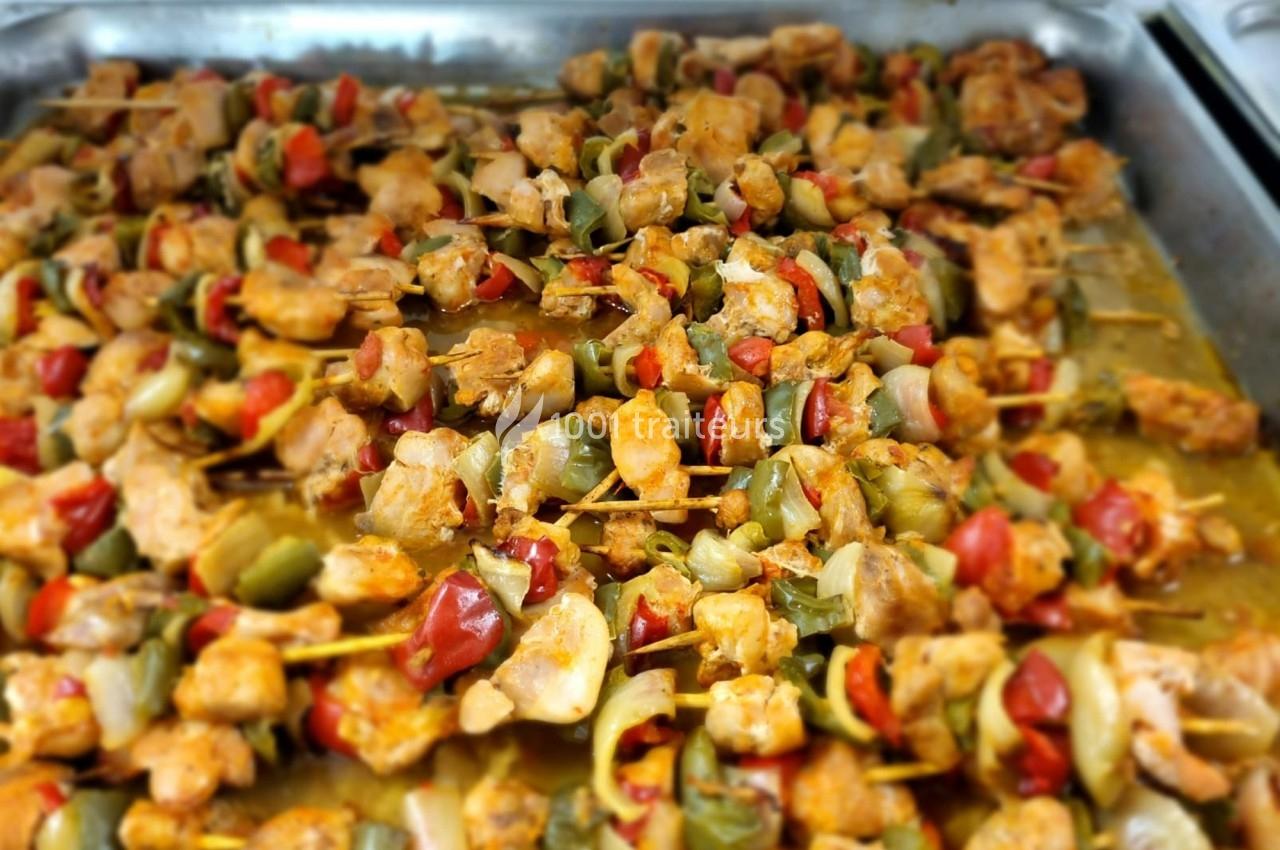 Brochettes de poulet marinées avec poivrons et oignons, disposées sur un plateau en métal.