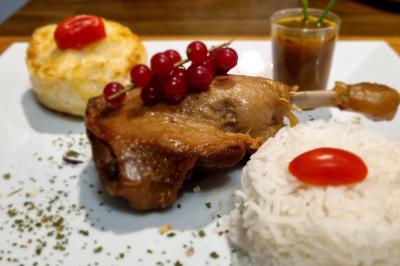Huîtres gratinées garnies de fromage et épices, présentées sur un plateau en bois, avec légumes en arrière-plan.