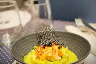 Bouteilles de champagne variées alignées sur une étagère réfrigérée, étiquettes visibles.