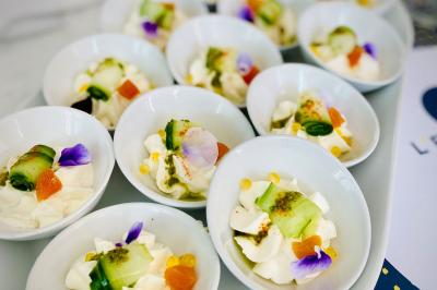 Bouteilles de champagne variées alignées sur une étagère réfrigérée, étiquettes visibles.