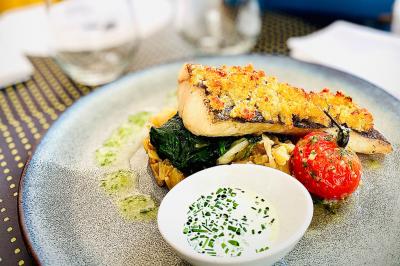 Bouteilles de champagne variées alignées sur une étagère réfrigérée, étiquettes visibles.