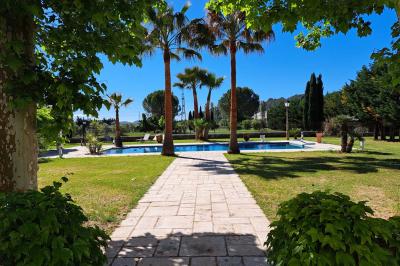 Décoration de table de mariage en extérieur avec chandeliers en verre, fleurs blanches et chaises alignées sur une pelouse.