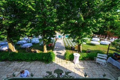 Décoration de table de mariage en extérieur avec chandeliers en verre, fleurs blanches et chaises alignées sur une pelouse.