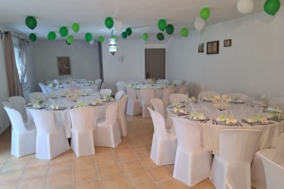 Décoration de table de mariage en extérieur avec chandeliers en verre, fleurs blanches et chaises alignées sur une pelouse.