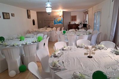 Décoration de table de mariage en extérieur avec chandeliers en verre, fleurs blanches et chaises alignées sur une pelouse.
