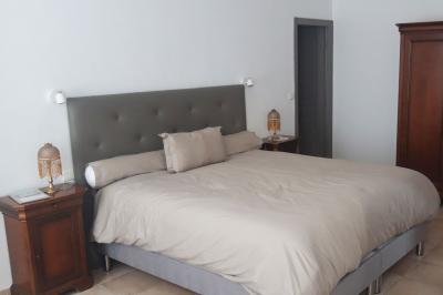 Décoration de table de mariage en extérieur avec chandeliers en verre, fleurs blanches et chaises alignées sur une pelouse.
