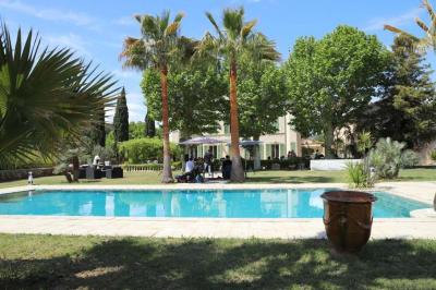 Décoration de table de mariage en extérieur avec chandeliers en verre, fleurs blanches et chaises alignées sur une pelouse.
