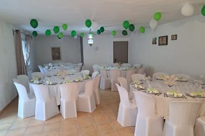 Décoration de table de mariage en extérieur avec chandeliers en verre, fleurs blanches et chaises alignées sur une pelouse.