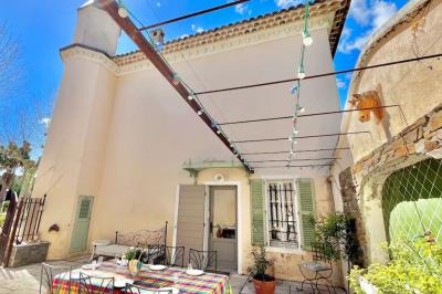 Décoration de table de mariage en extérieur avec chandeliers en verre, fleurs blanches et chaises alignées sur une pelouse.
