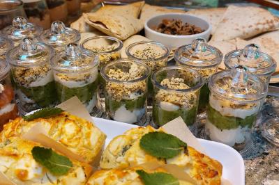 Assiette de triangles de pâte garnis d'une farce crémeuse, décorés de persil et disposés en cercle.