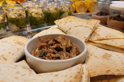 Assiette de triangles de pâte garnis d'une farce crémeuse, décorés de persil et disposés en cercle.
