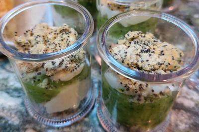 Assiette de triangles de pâte garnis d'une farce crémeuse, décorés de persil et disposés en cercle.