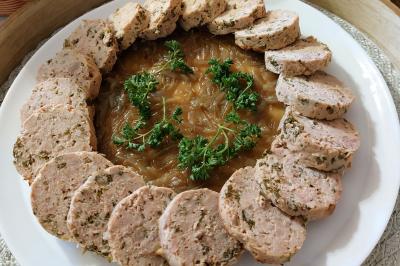 Assiette de triangles de pâte garnis d'une farce crémeuse, décorés de persil et disposés en cercle.