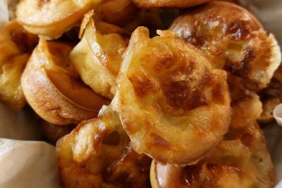 Assiette de triangles de pâte garnis d'une farce crémeuse, décorés de persil et disposés en cercle.