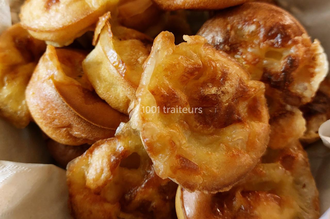 Beignets dorés et croustillants empilés dans un récipient, avec une texture légèrement caramélisée.
