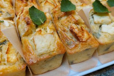 Assiette de triangles de pâte garnis d'une farce crémeuse, décorés de persil et disposés en cercle.