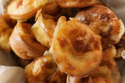 Assiette de triangles de pâte garnis d'une farce crémeuse, décorés de persil et disposés en cercle.