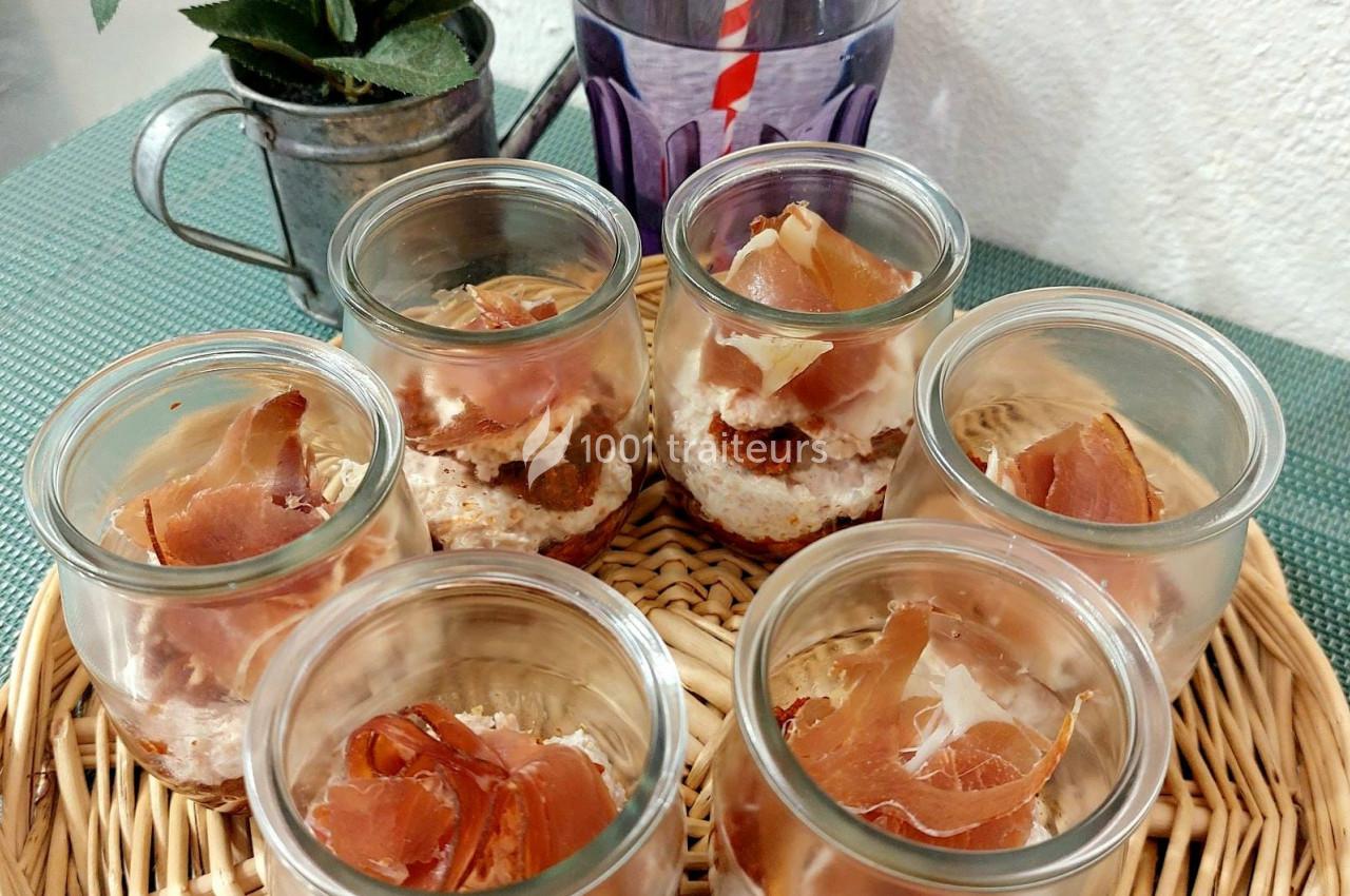 Six verrines garnies de mousse et de tranches de jambon cru, présentées sur un plateau en osier.