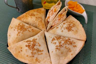 Assiette de triangles de pâte garnis d'une farce crémeuse, décorés de persil et disposés en cercle.