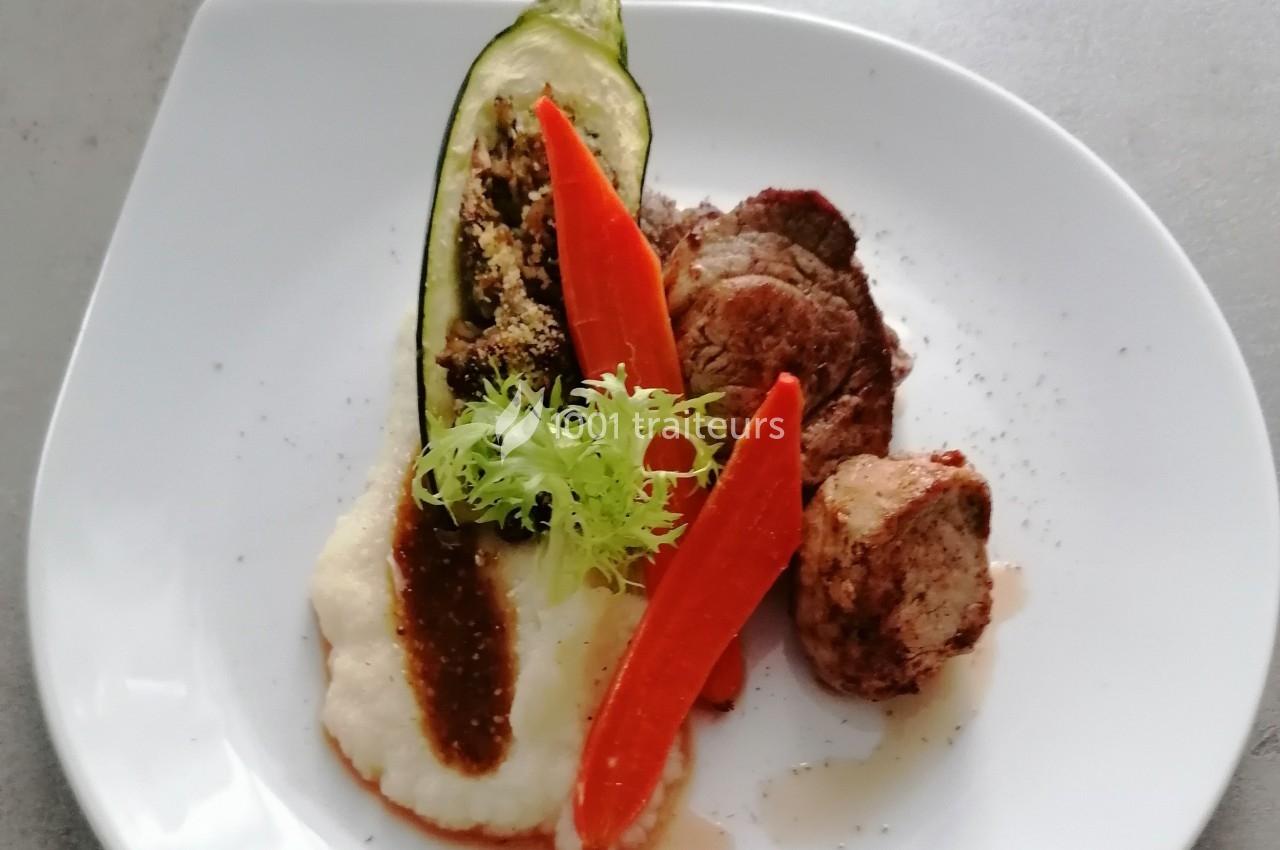 Assiette composée de médaillons de viande, purée, carottes glacées, courgette farcie et sauce, servie sur une assiette…